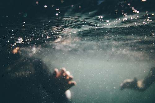 water underwater photo of person wearing black shirt grey